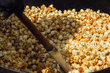 Kettle corn being stirred in a copper kettle